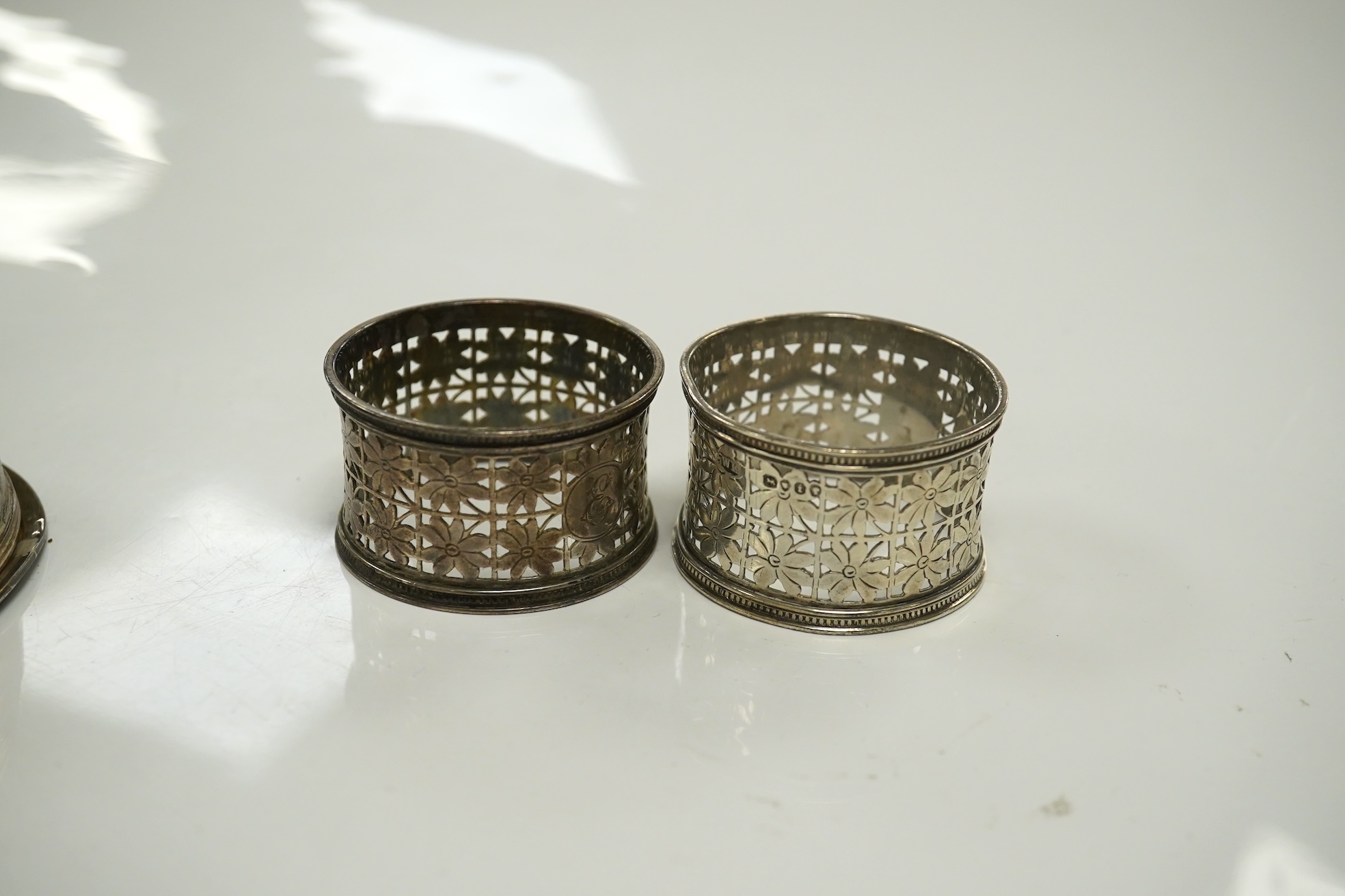 Two pairs of Victorian silver napkin rings and a George III silver wine funnel with later embossed decoration, 14.1cm. Condition - poor to fair